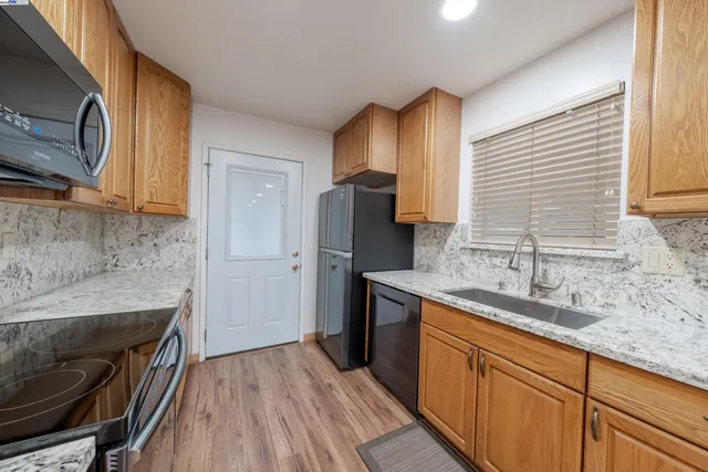 a kitchen with stainless steel appliances granite countertop a sink stove and refrigerator