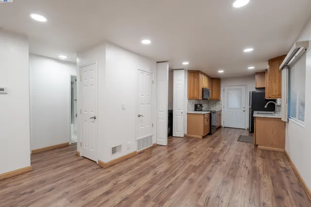 a view of kitchen with wooden floor and electronic appliances