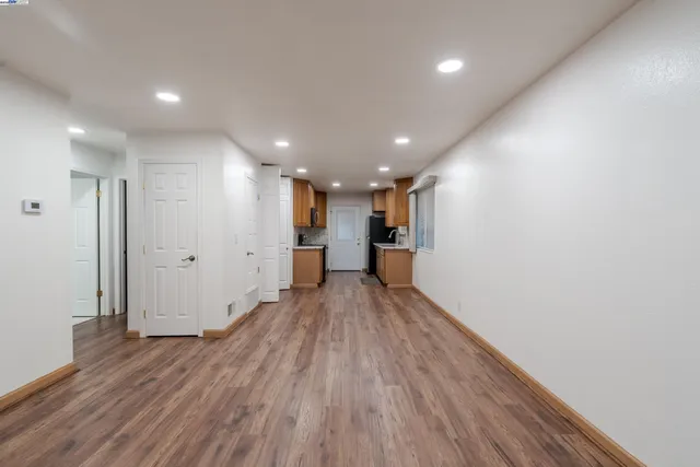 a view of empty room with wooden floor