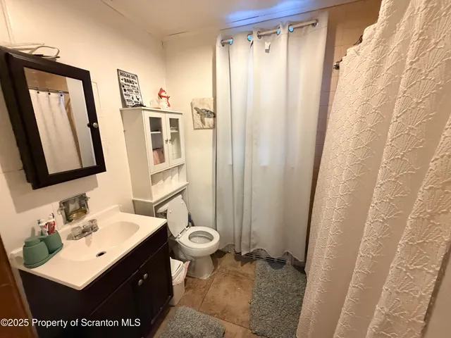 a bathroom with a sink mirror vanity and toilet