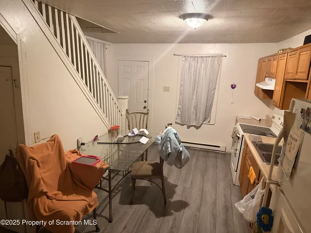a living room with furniture a flat screen tv and a wooden floor