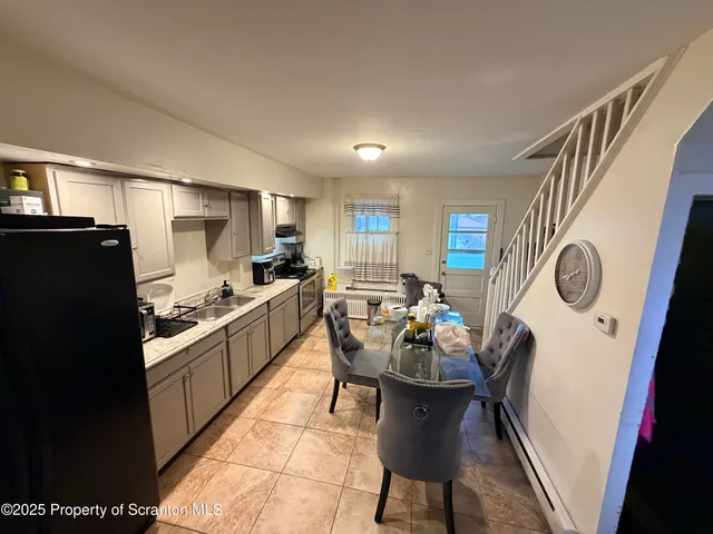 a kitchen with granite countertop a sink stove and refrigerator