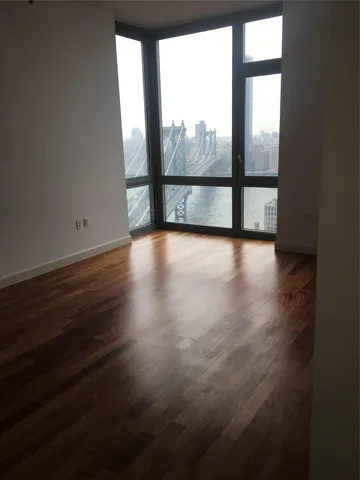 a view of a room with wooden floor and a window
