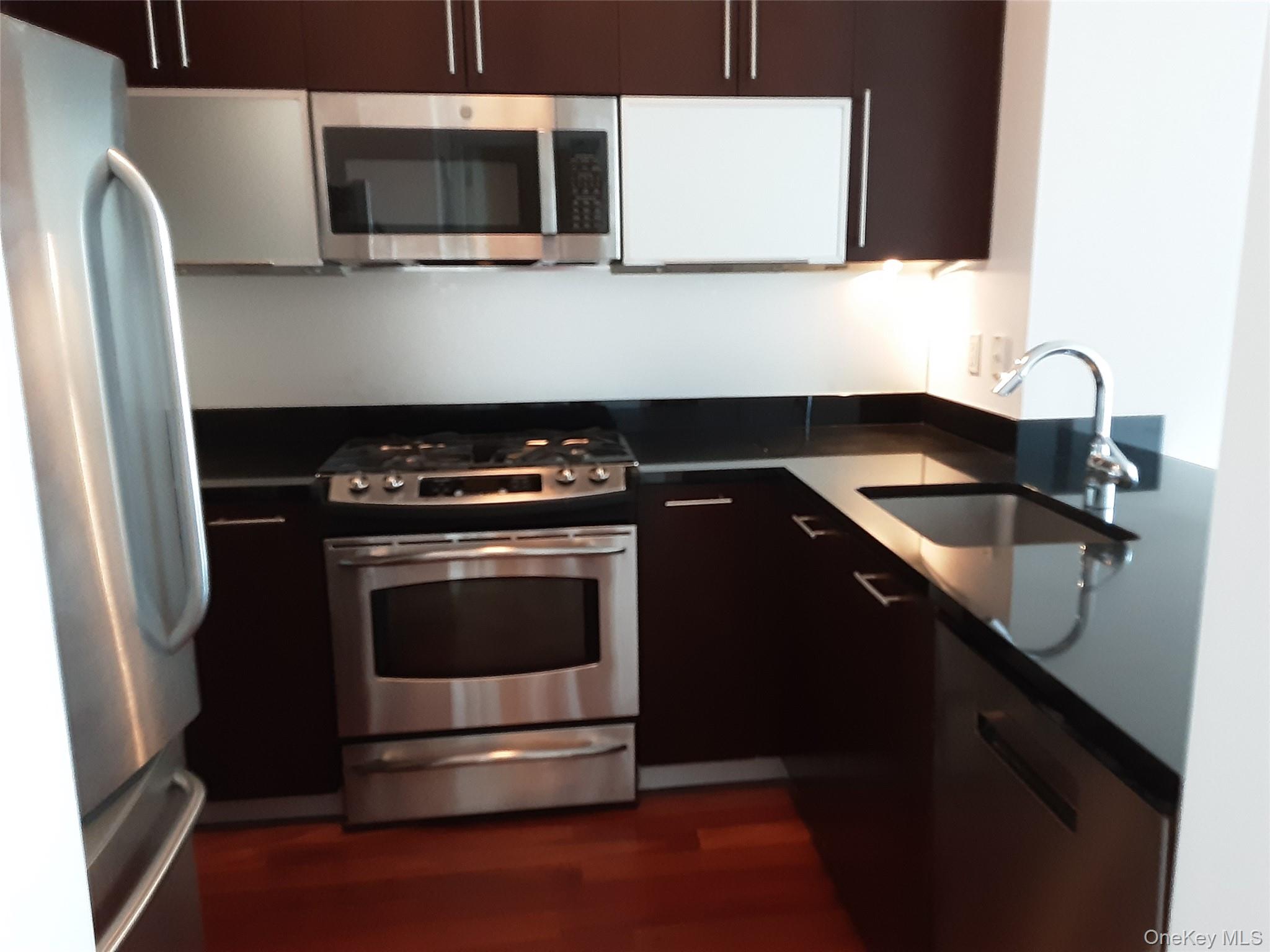 100 Jay Street, Unit 28B Brooklyn, NY 11201 - Photo 25 of 47 a kitchen with stainless steel appliances a stove microwave and sink