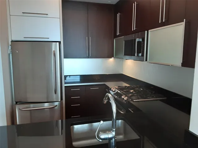 a kitchen with a refrigerator and a stove top oven
