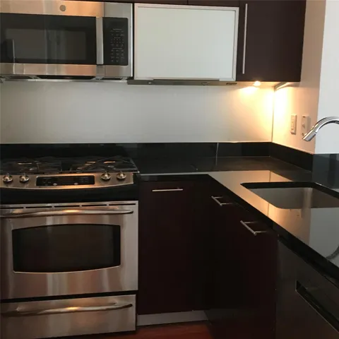 a kitchen with granite countertop a stove and a microwave