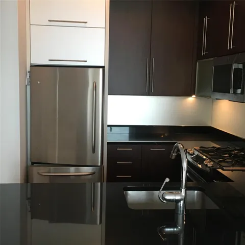 a kitchen with a refrigerator and a stove top oven