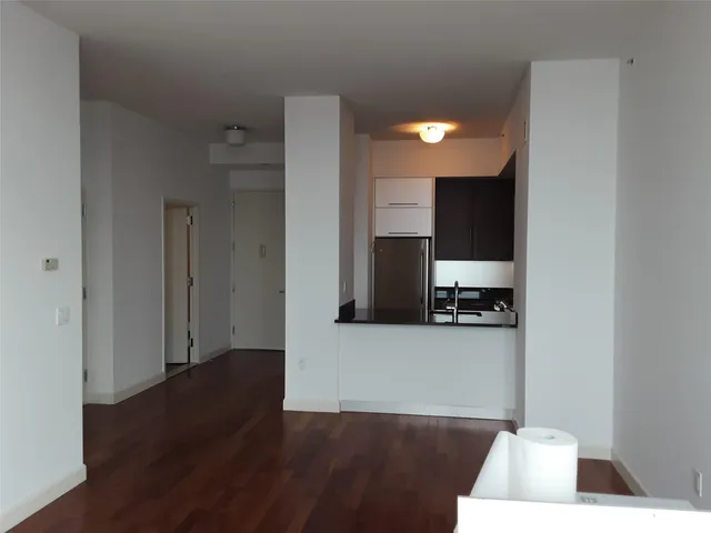 a view of a living room with wooden floor and a flat screen tv