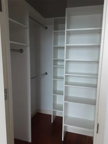 a view of walk in closet with empty racks