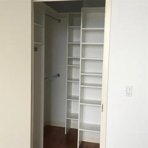 a view of walk in closet with empty racks
