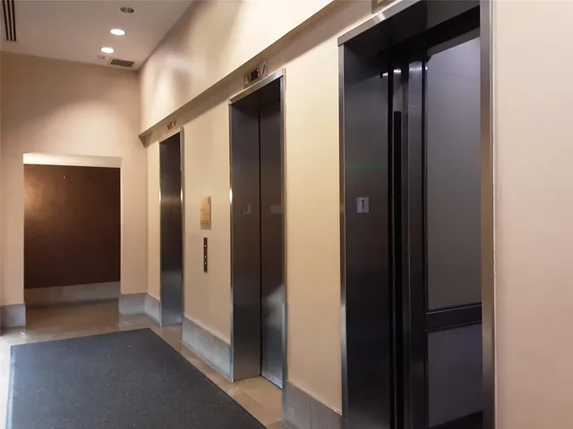 a view of a hallway with stainless steel appliances