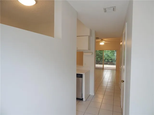 a view of a hallway with wooden floor and a bathroom
