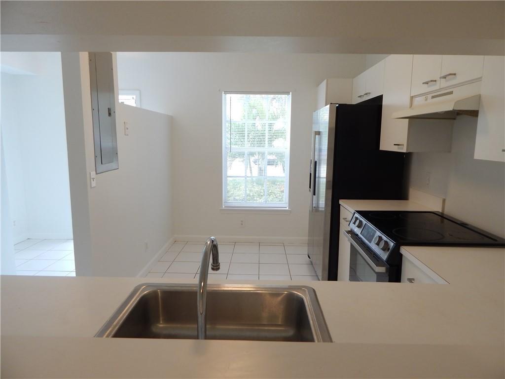 9914 Northwest 56th Place Coral Springs, FL 33076 - Photo 6 of 19 a kitchen with a sink a refrigerator and a window