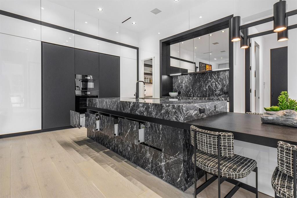 202 Northwest 7th Street Delray Beach, FL 33444 - Photo 15 of 100 a kitchen with stainless steel appliances kitchen island granite countertop a table chairs in it and wooden floors