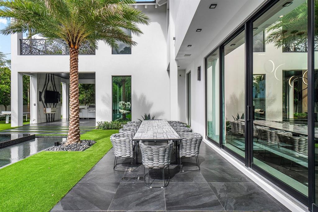 202 Northwest 7th Street Delray Beach, FL 33444 - Photo 72 of 100 a view of a patio with table and chairs and potted plants with floor to ceiling window