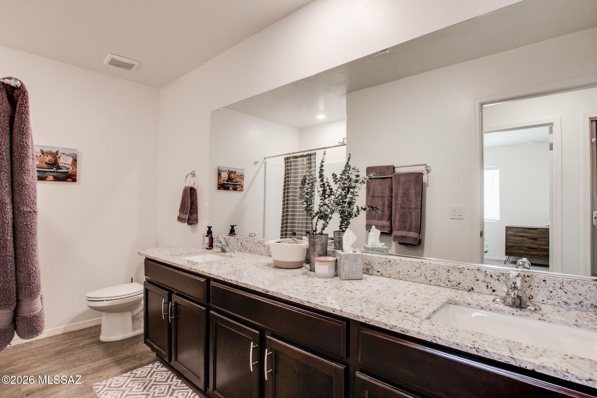 7056 South Draper Road Tucson, AZ 85757 - Photo 14 of 22 a bathroom with double vanity sinks a toilet and a large mirror