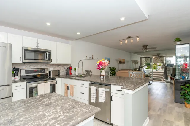 a kitchen with granite countertop a sink and cabinets