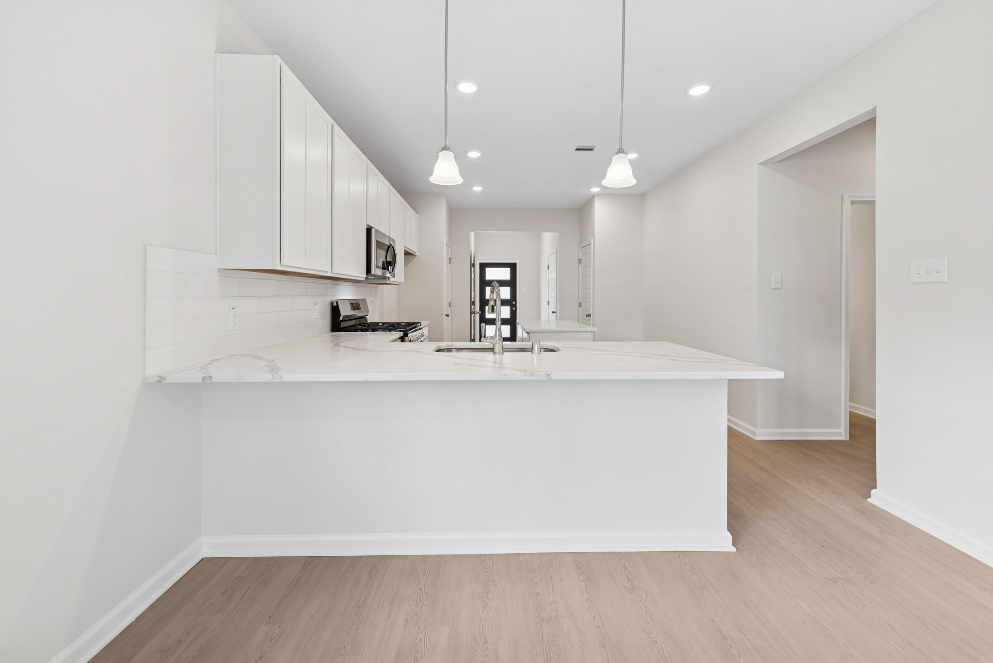 537 Stone Placa Trail Pattison, TX 77423 - Photo 6 of 28 a view of a kitchen with kitchen island a sink wooden floor and a refrigerator