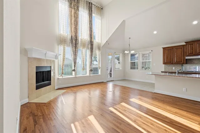 a view of a kitchen with granite countertop a stove top oven a sink with wooden floor