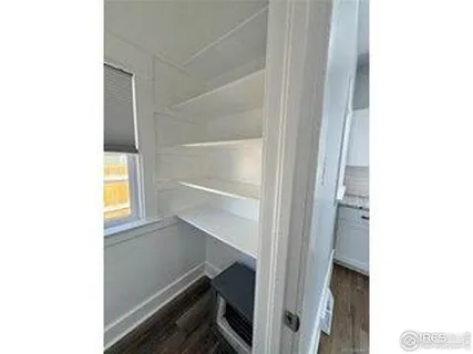 an empty room with wooden floor & windows and bathroom