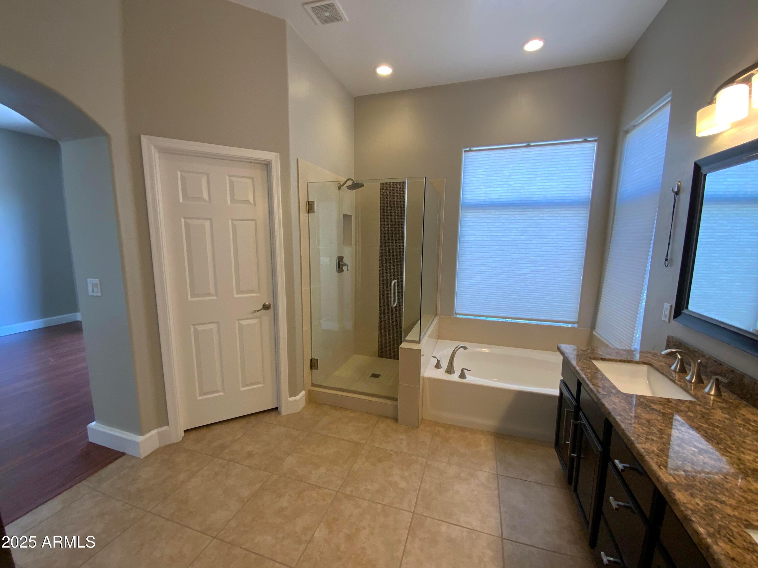 6204 East Phelps Road Scottsdale, AZ 85254 - Photo 14 of 25 a bathroom with a tub a sink and a large mirror