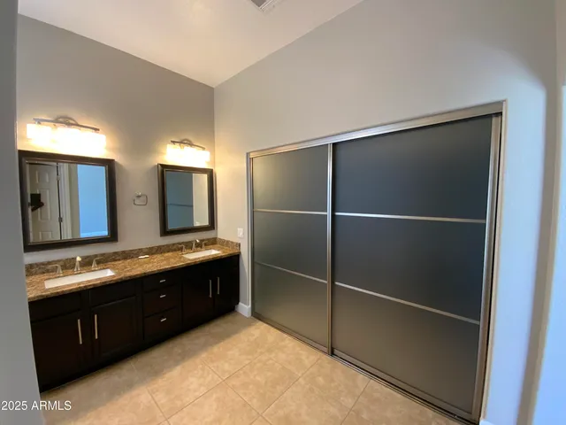 a view of a house with a yard potted plants and a large tree