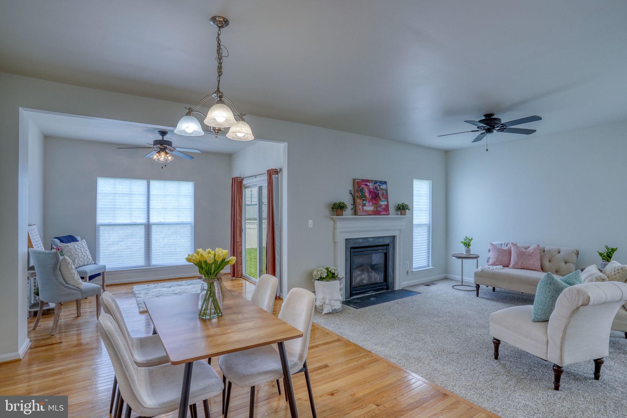 305 Appleby School Road Cambridge, MD 21613 - Photo 15 of 53 a view of a dining room with furniture a fireplace and wooden floor