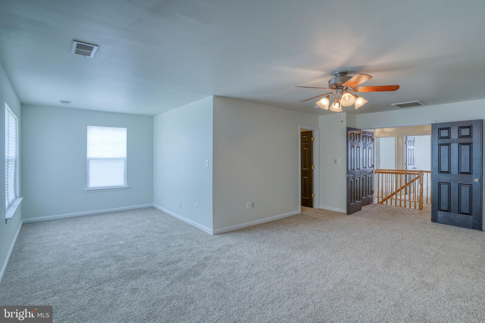 305 Appleby School Road Cambridge, MD 21613 - Photo 31 of 53 an empty room with chandelier fan and windows