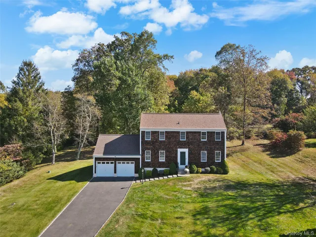 a view of a big house with a big yard and large trees