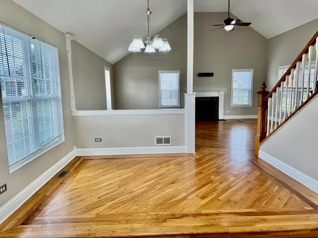 a view of a livingroom with wooden floor and a kitchen