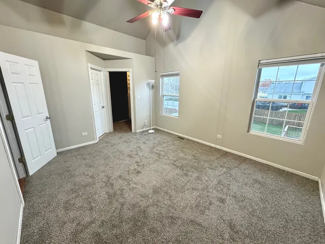 an empty room with windows and cabinet