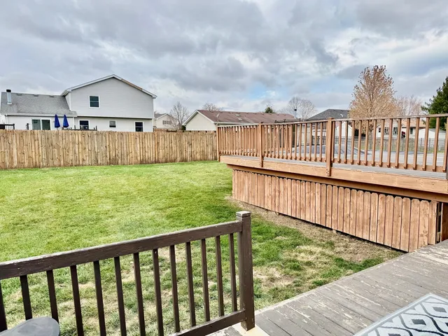 a view of a house with wooden deck and a yard