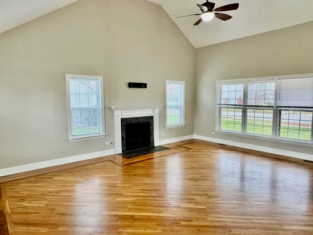 a view of empty room with wooden floor and fireplace