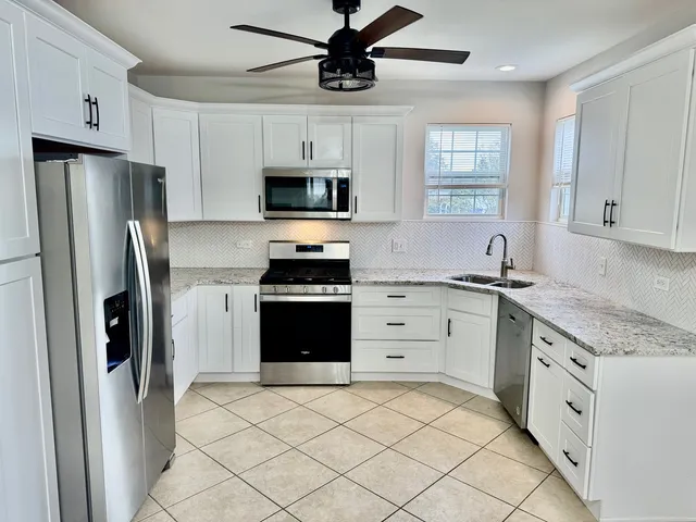a kitchen with stainless steel appliances a refrigerator stove and microwave