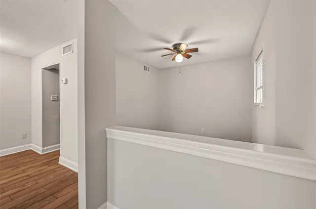 a view of empty room with wooden floor