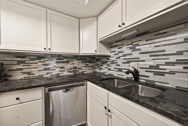 a kitchen with granite countertop a sink and cabinets