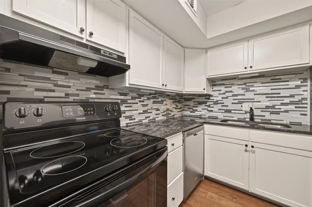 a kitchen with a stove and white cabinets