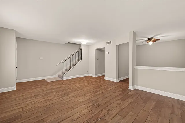 a view of an empty room with wooden floor