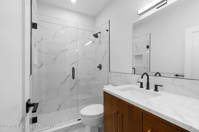 a bathroom with a sink toilet double vanity and shower