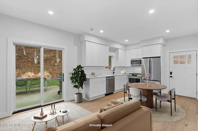 a living room with furniture a large window and kitchen view