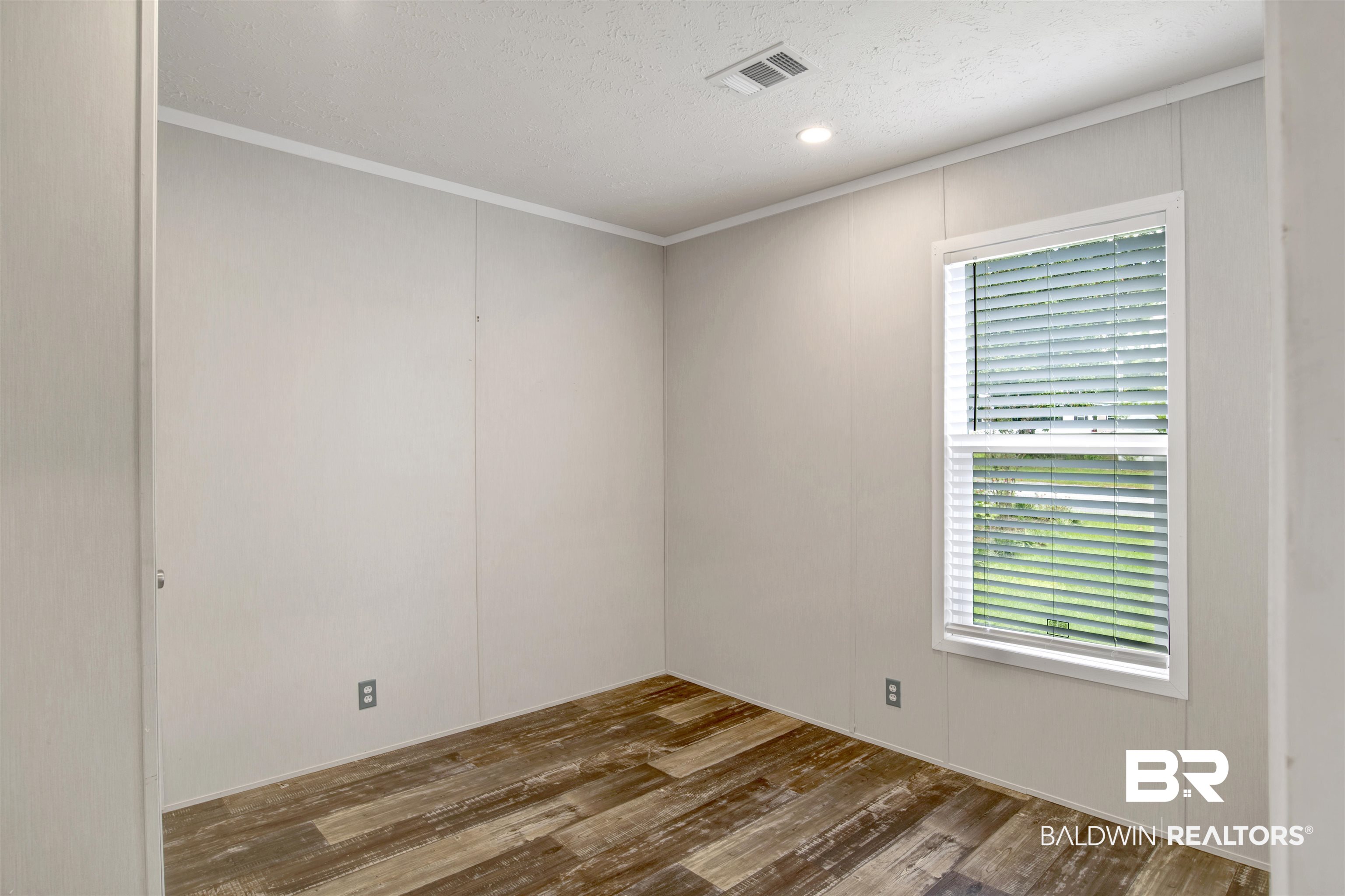 1411 Ridgewood Drive Lillian, AL 36549 - Photo 26 of 30 Spare room featuring a textured ceiling, crown molding, and dark hardwood / wood-style flooring