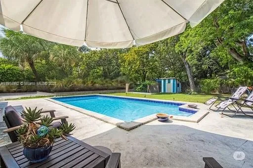 a view of a swimming pool with a patio and a yard