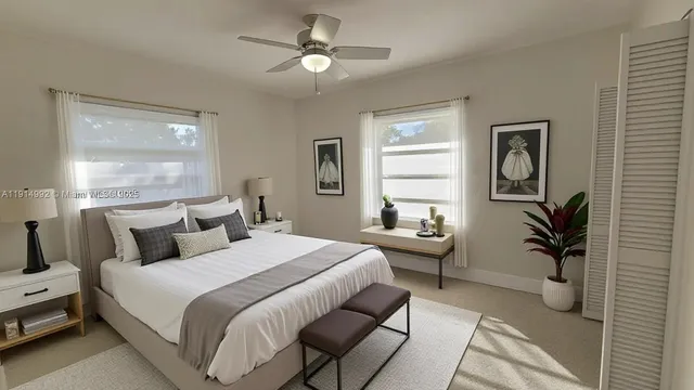 a bedroom with a bed couch and windows