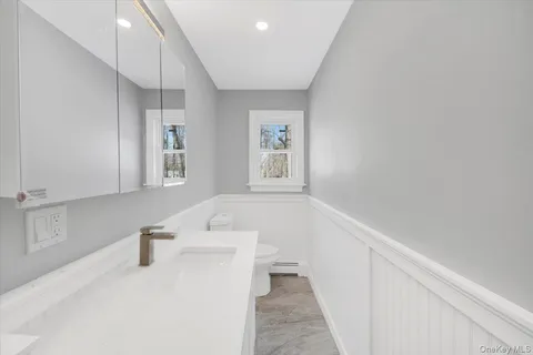 a hallway with a white cabinets and window