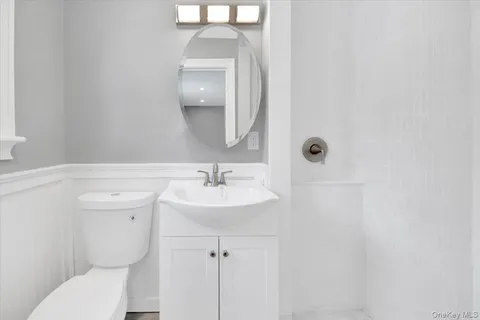 a bathroom with a toilet a sink and mirror