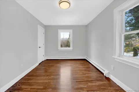 a view of a livingroom with wooden floor and window