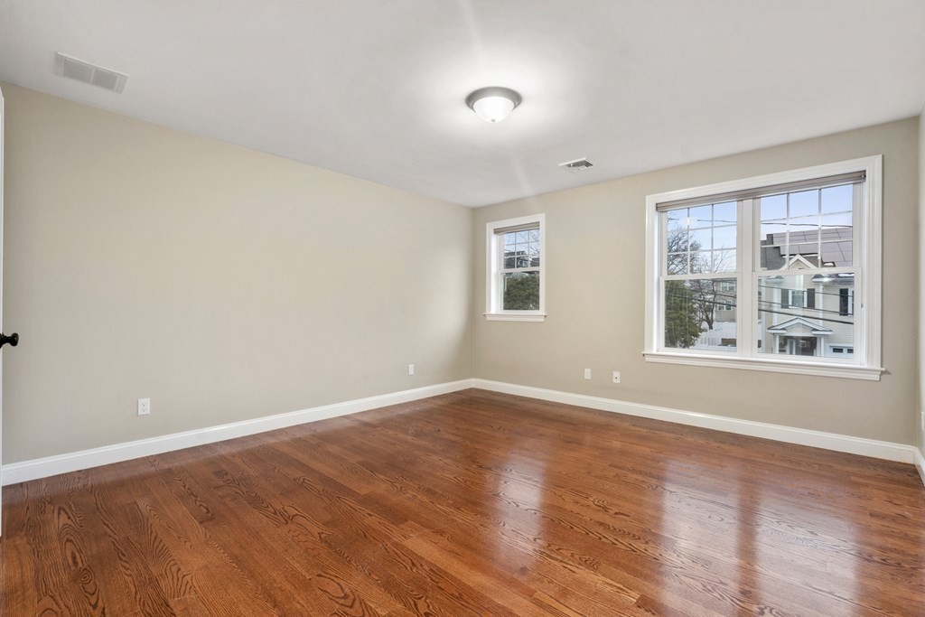 24 Crescent Road, Unit 1 Needham, MA 02494 - Photo 11 of 20 a view of an empty room with wooden floor and a window