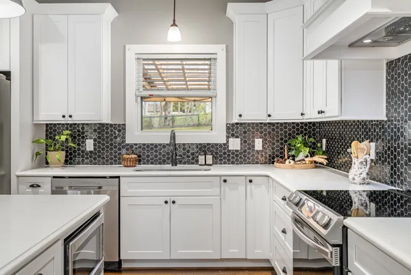 a kitchen with white cabinets and white appliances