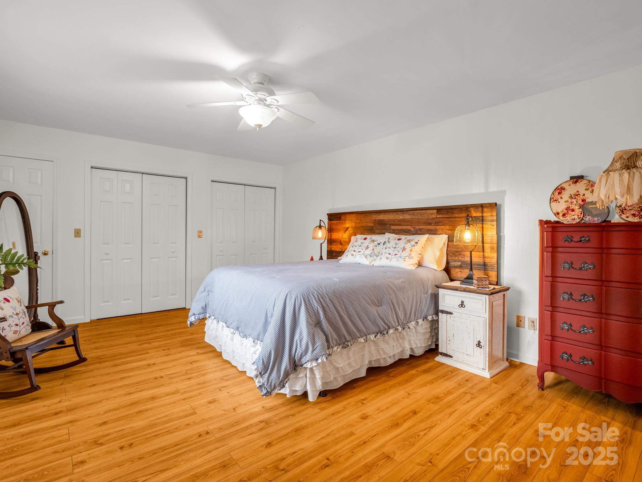 1145 Bearwallow Mountain Road Hendersonville, NC 28792 - Photo 16 of 48 a bedroom with a large bed and a chandelier