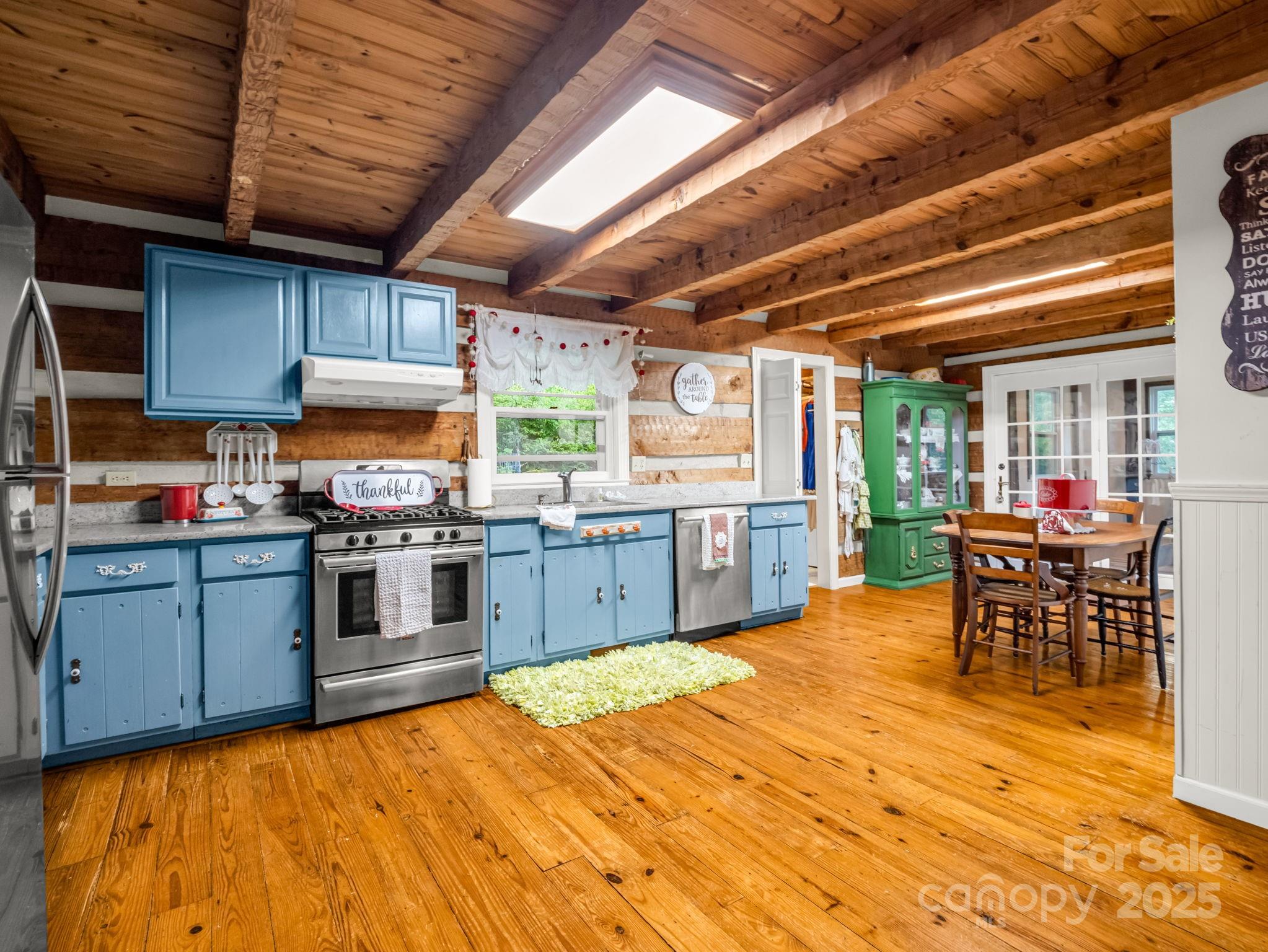 1145 Bearwallow Mountain Road Hendersonville, NC 28792 - Photo 18 of 48 a kitchen with stainless steel appliances kitchen island granite countertop a table chairs and a wooden cabinets